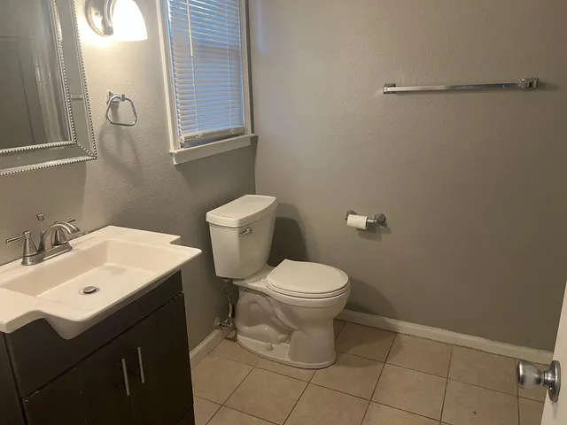 a bathroom with a toilet sink and mirror