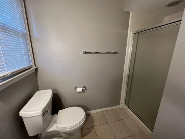a white toilet sitting next to a shower