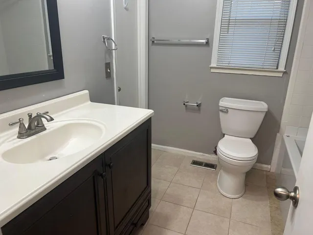 a bathroom with a toilet sink and mirror