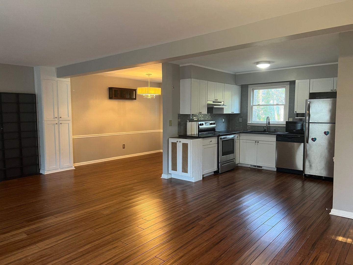 5912 Pine Tree Court Raleigh, NC 27609 - Photo 2 of 18 a kitchen with stainless steel appliances a microwave a stove a sink dishwasher and a refrigerator with wooden floor