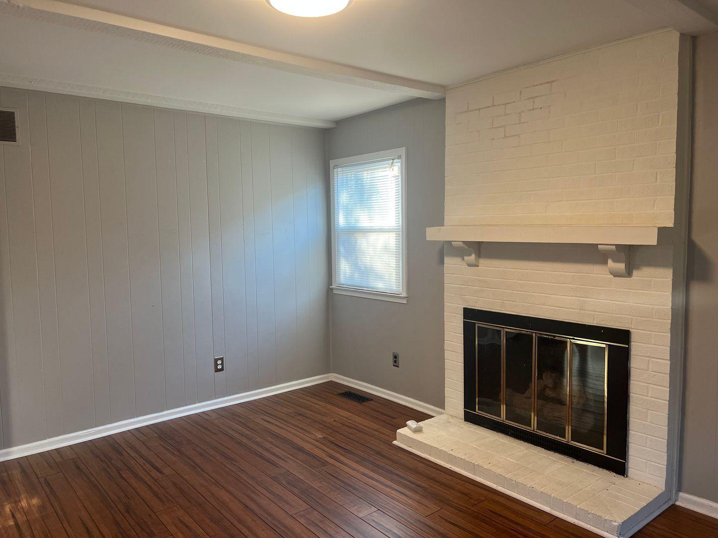5912 Pine Tree Court Raleigh, NC 27609 - Photo 10 of 18 a view of empty room with wooden floor and fireplace