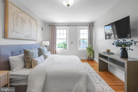 a bedroom with a large bed and a flat tv screen on dresser