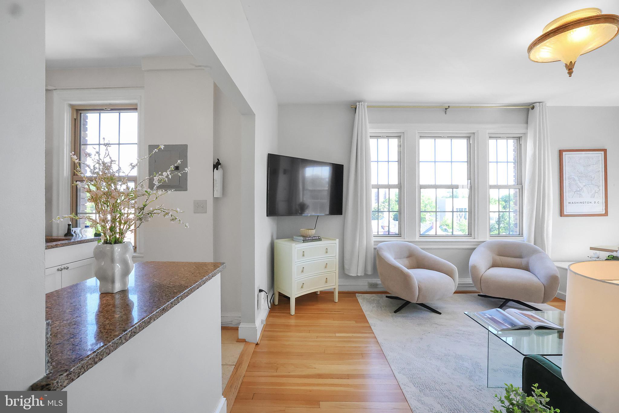 3446 Connecticut Avenue Northwest, Unit 502 Washington, DC 20008 - Photo 3 of 35 a living room with furniture a flat screen tv and a large window