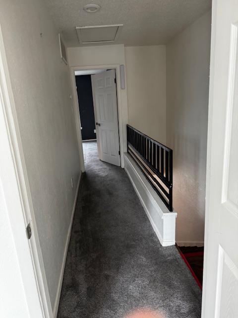 2018 West Rundberg Lane, Unit 6C Austin, TX 78758 - Photo 14 of 29 Upstair corridor between bedrooms with dark colored carpet and a textured ceiling