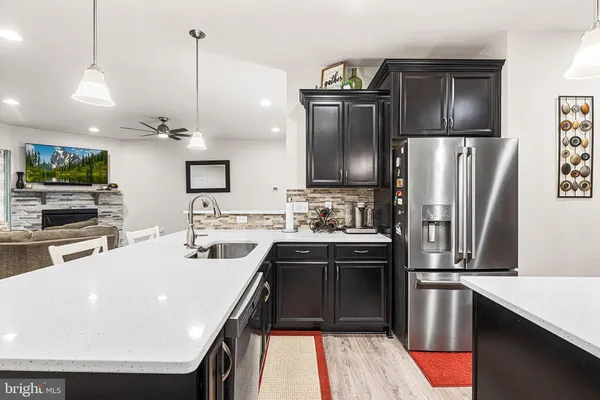 a kitchen with stainless steel appliances granite countertop a sink a stove and a refrigerator