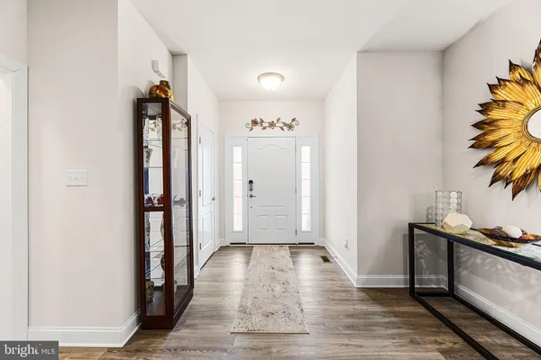 a view of a hallway with wooden floor and a living room