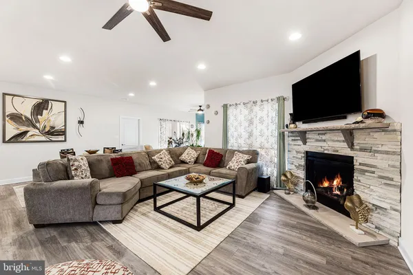 a living room with furniture a flat screen tv and a fireplace