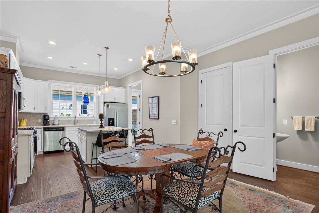 112 Tuttle Street Clemson, SC 29631 - Photo 12 of 46 A well-lit kitchen and dining area, featuring sleek appliances and rich hardwood floors.