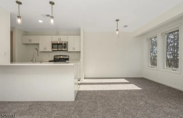 a kitchen with kitchen island white cabinets and refrigerator