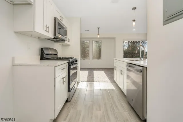 a kitchen with stainless steel appliances granite countertop a stove and a refrigerator
