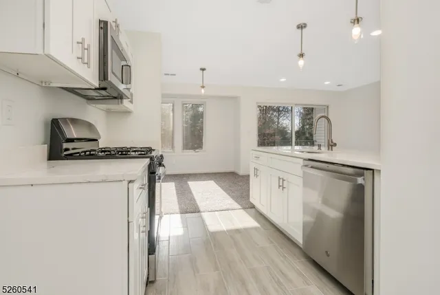 a kitchen with stainless steel appliances a stove a sink and a refrigerator