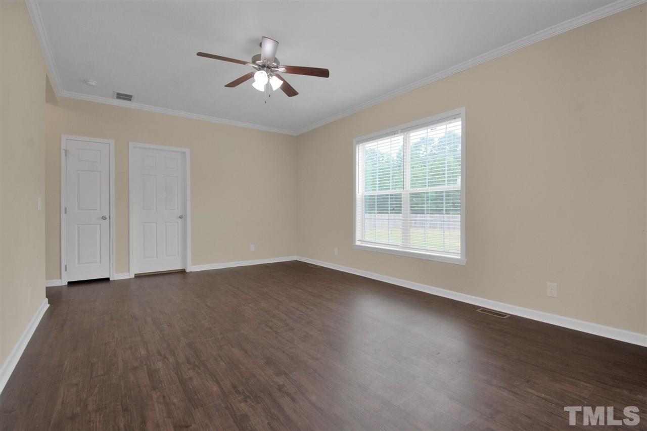 1298 L L Cooper Road Cameron, NC 28326 - Photo 6 of 30 a view of an empty room with wooden floor and a window