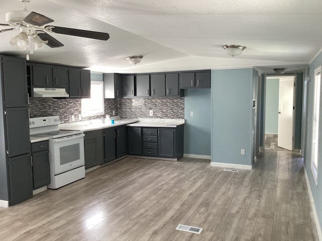 a kitchen with stainless steel appliances granite countertop a sink window and cabinets