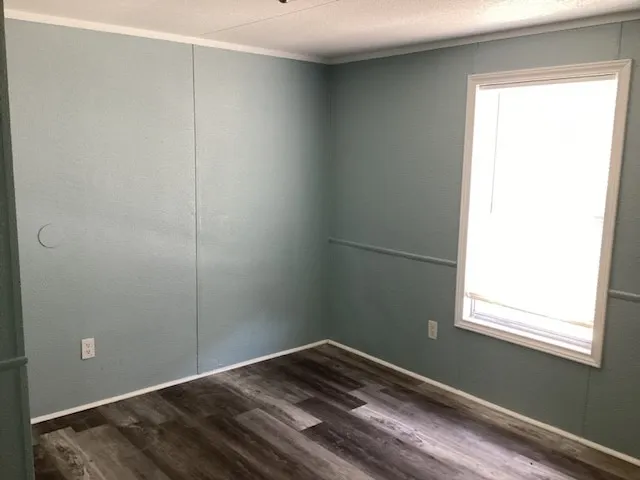 a view of a room with wooden floor and a window