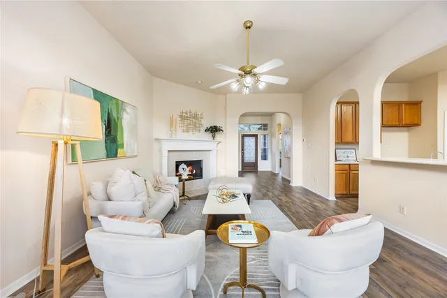 a living room with furniture a fireplace and a chandelier