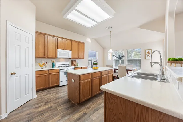 a kitchen with stainless steel appliances sink stove microwave and cabinets
