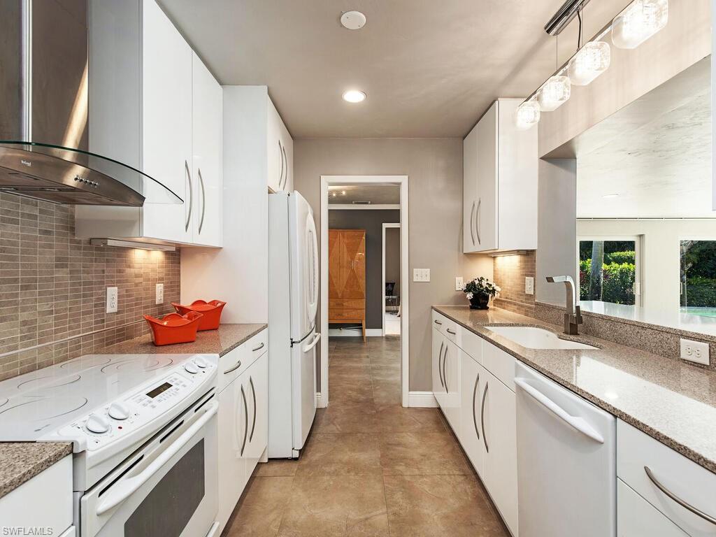 540 Rudder Road Naples, FL 34102 - Photo 4 of 12 a kitchen with stainless steel appliances a sink stove and cabinets