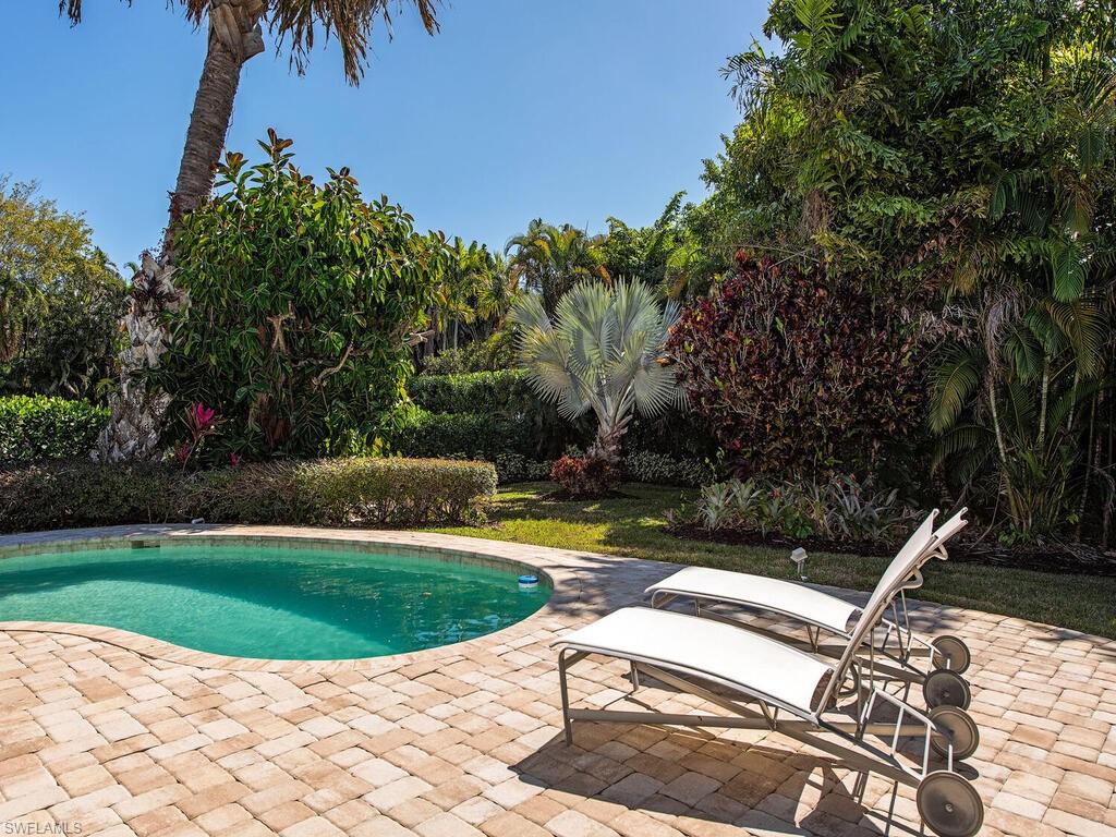 540 Rudder Road Naples, FL 34102 - Photo 7 of 12 a view of a swimming pool with a garden