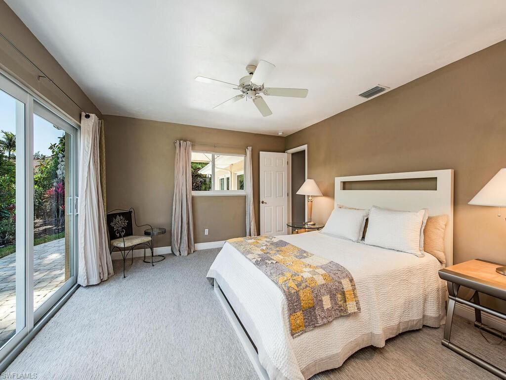 540 Rudder Road Naples, FL 34102 - Photo 10 of 12 a bedroom with a bed and a chandelier