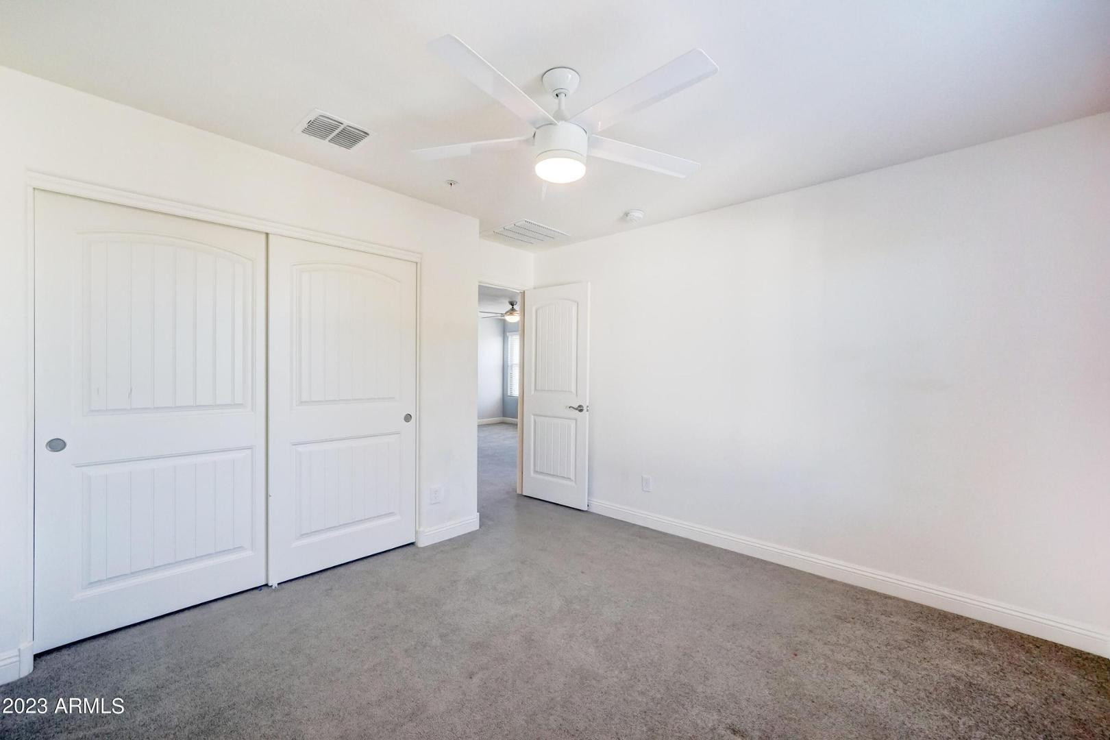 2297 North Alsap Road Buckeye, AZ 85396 - Photo 22 of 36 an empty room with a ceiling fan and a window