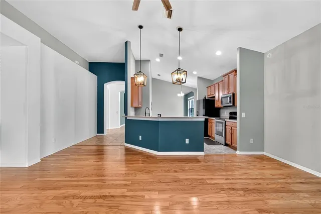 a view of a kitchen with kitchen island and stainless steel appliances