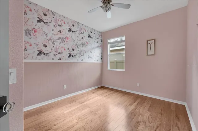 a view of an empty room with a window and a dresser