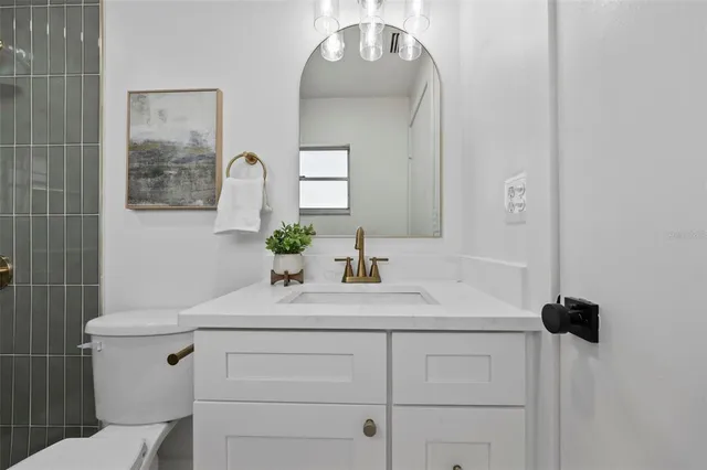 a bathroom with a sink vanity and toilet