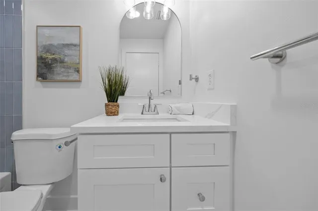 a bathroom with a sink a toilet and mirror
