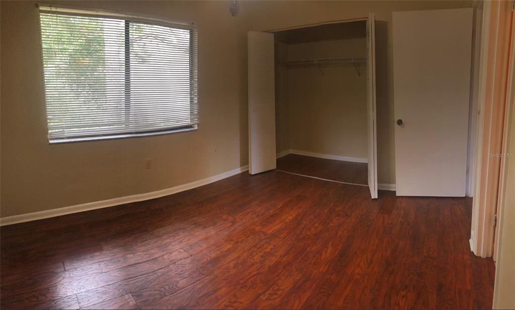 2735 Southwest 35th Place, Unit 403 Gainesville, FL 32608 - Photo 6 of 11 an empty room with wooden floor and windows