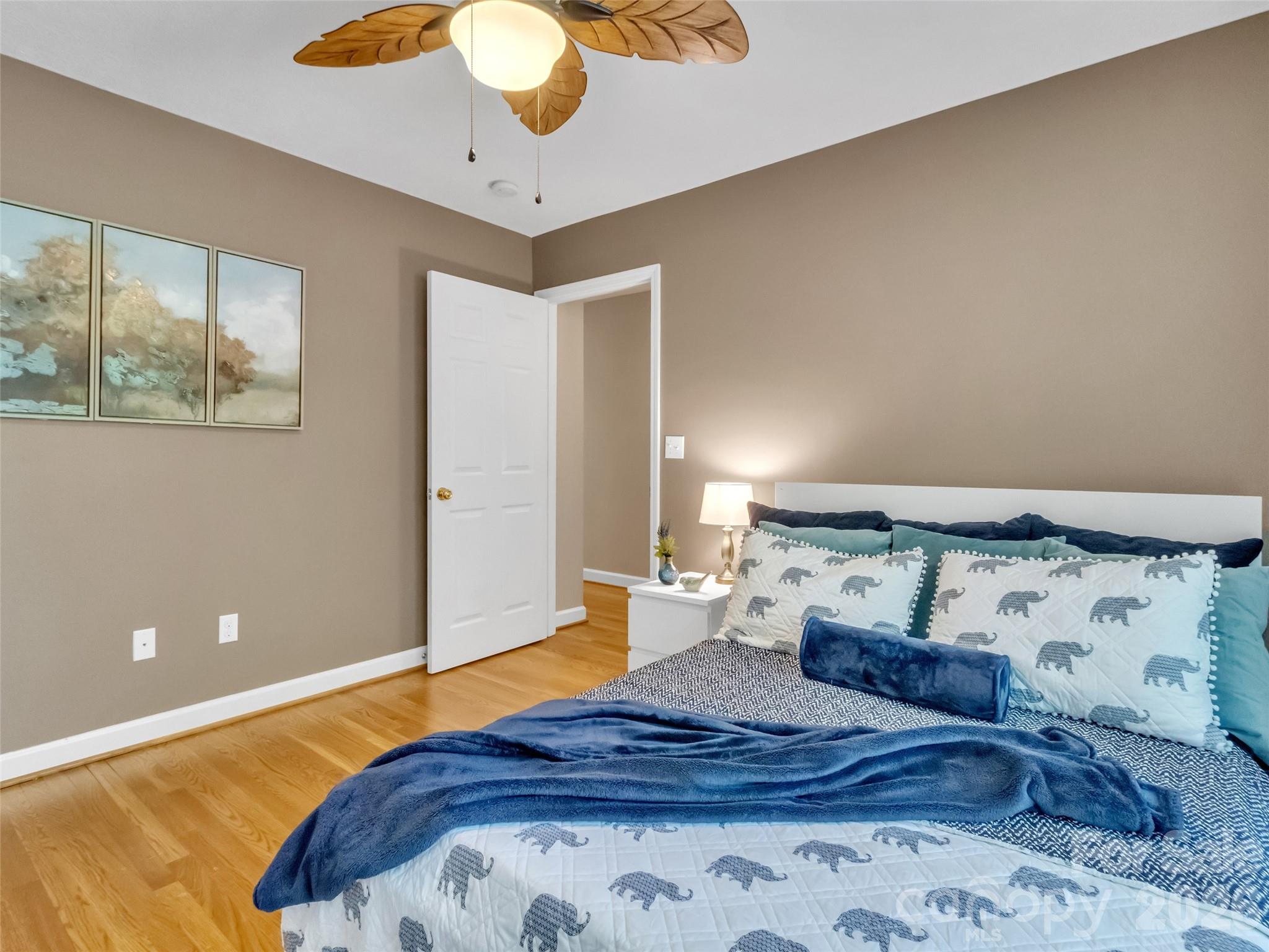 88 Adams Drive Clyde, NC 28721 - Photo 21 of 47 a bedroom with a large bed and a chandelier