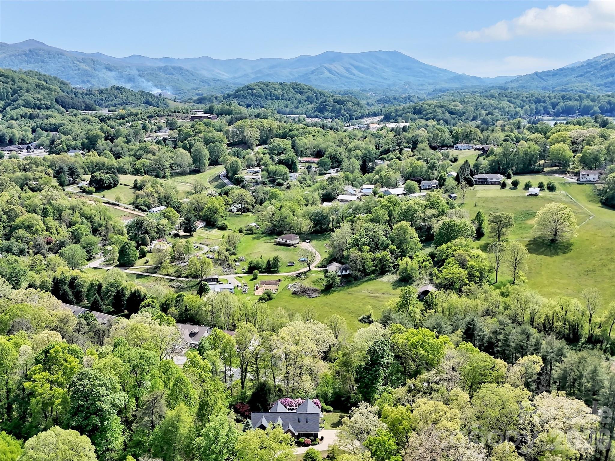 88 Adams Drive Clyde, NC 28721 - Photo 45 of 47 a view of a lush green field with mountains in the background