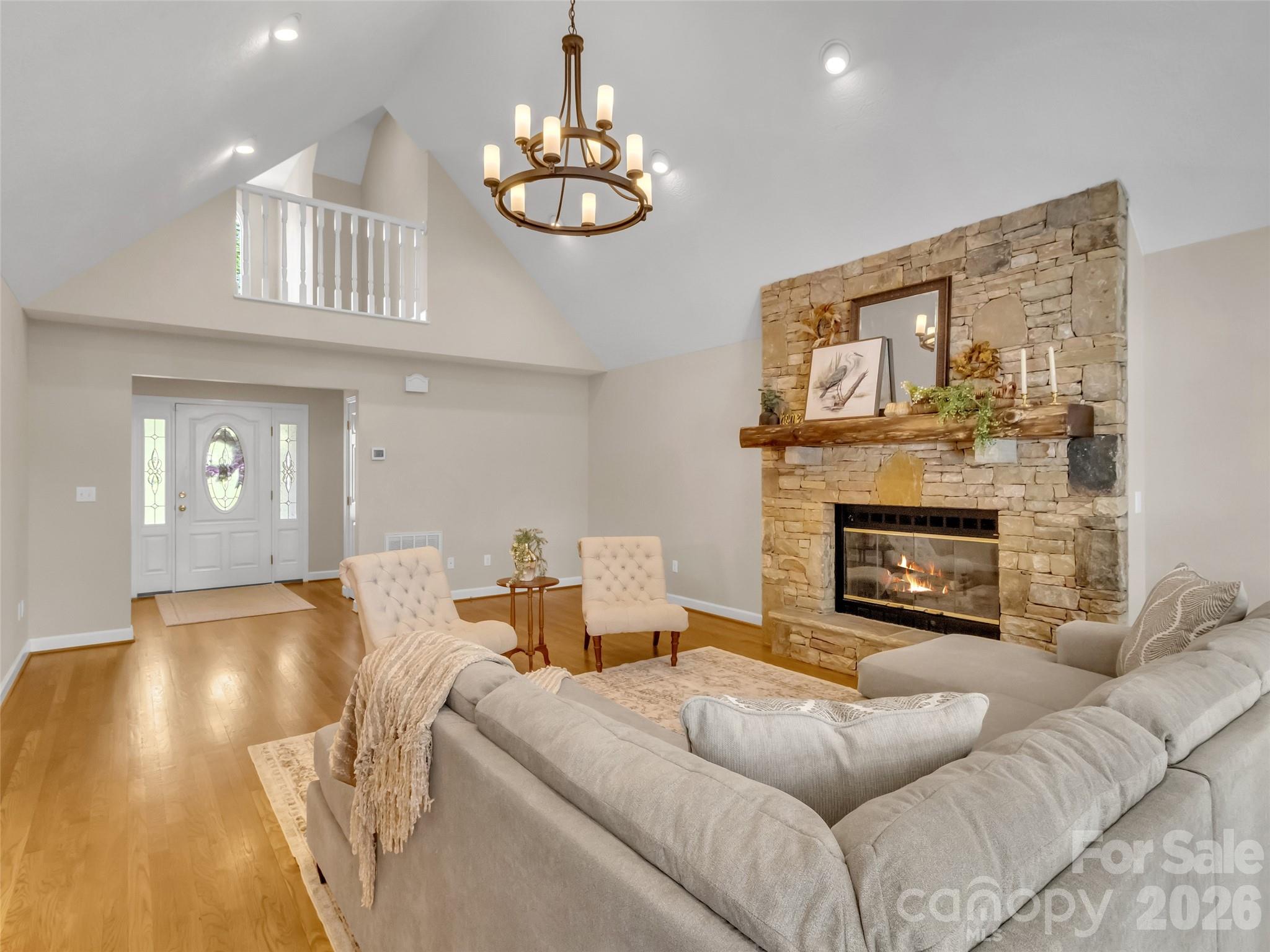 88 Adams Drive Clyde, NC 28721 - Photo 7 of 47 a living room with furniture a fireplace and chandelier