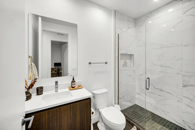 a bathroom with a sink toilet a mirror and shower