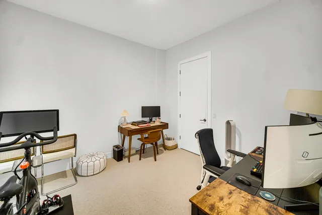 a view of a workspace with furniture and a window