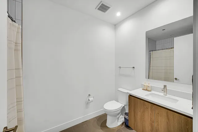 a bathroom with a sink vanity mirror and toilet