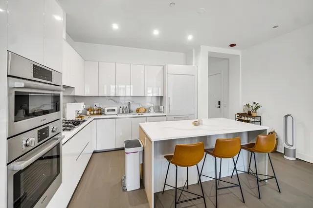 a kitchen with stainless steel appliances kitchen island granite countertop a stove a sink a microwave and a refrigerator