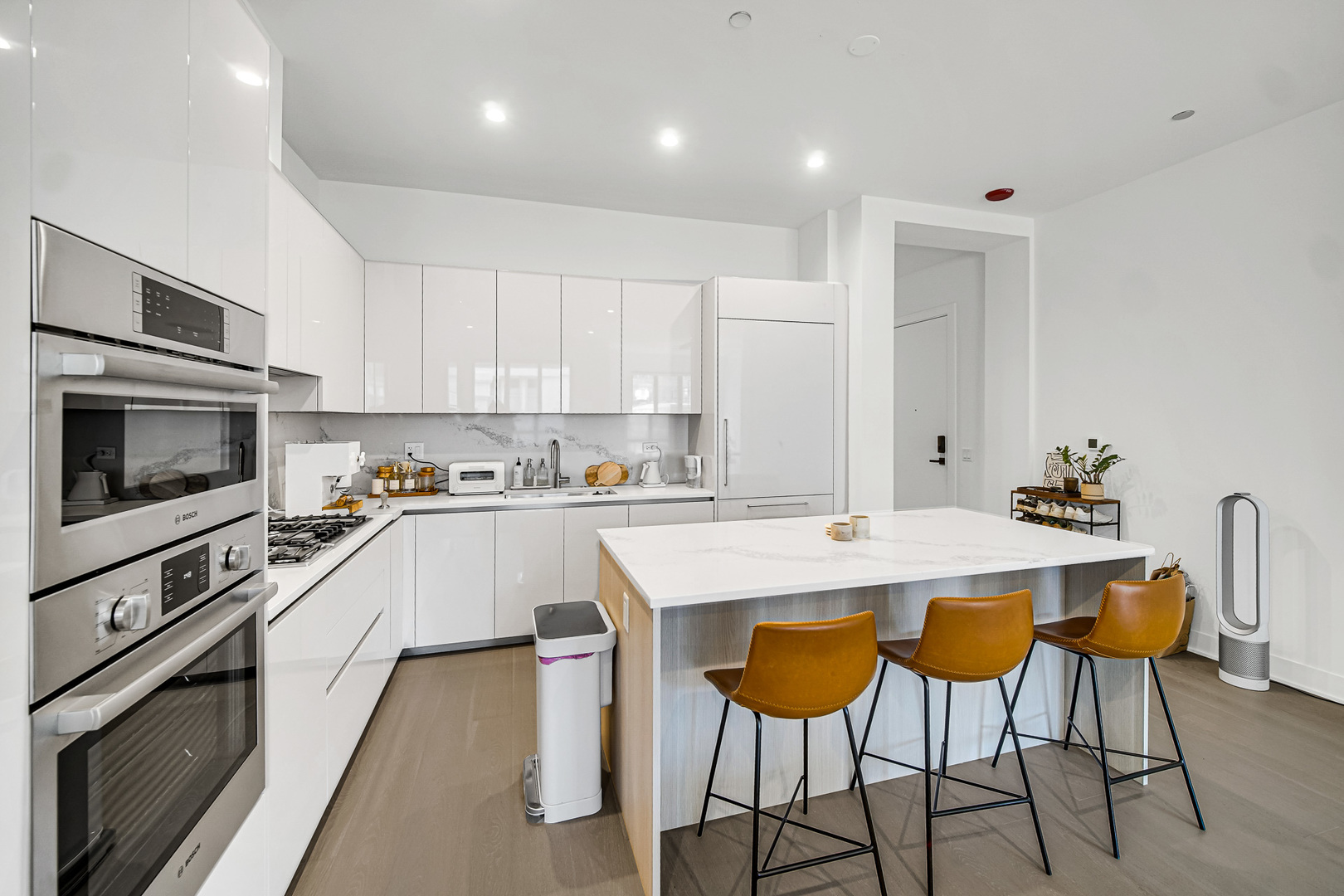 323 South Racine Avenue, Unit 5A Chicago, IL 60607 - Photo 4 of 26 a kitchen with stainless steel appliances kitchen island granite countertop a stove a sink a microwave and a refrigerator
