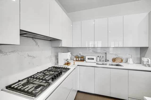 a kitchen with white cabinets and appliances