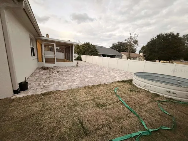 a view of a house with backyard and trees