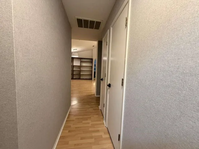 a view of a hallway with wooden floor
