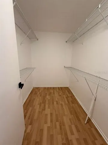 a view of walk in closet with empty racks