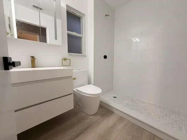 a bathroom with a toilet sink and mirror