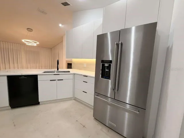 a kitchen with stainless steel appliances a refrigerator sink and cabinets