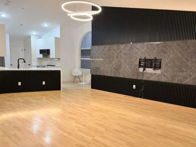 a view of kitchen with stainless steel appliances granite countertop cabinets and wooden floor