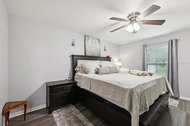 a bedroom with bed and wooden floor