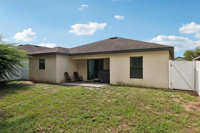 a backyard of a house with table and chairs
