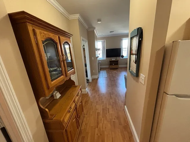 a view of a hallway with wooden floor and stairs
