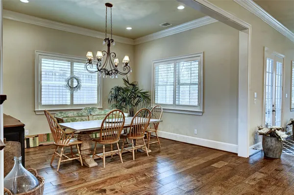 a dining room with furniture a chandelier and wooden floor