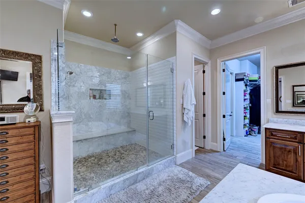 a spacious bathroom with a glass shower door and a sink