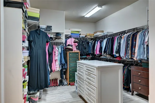 a view of walk in closet with clothes